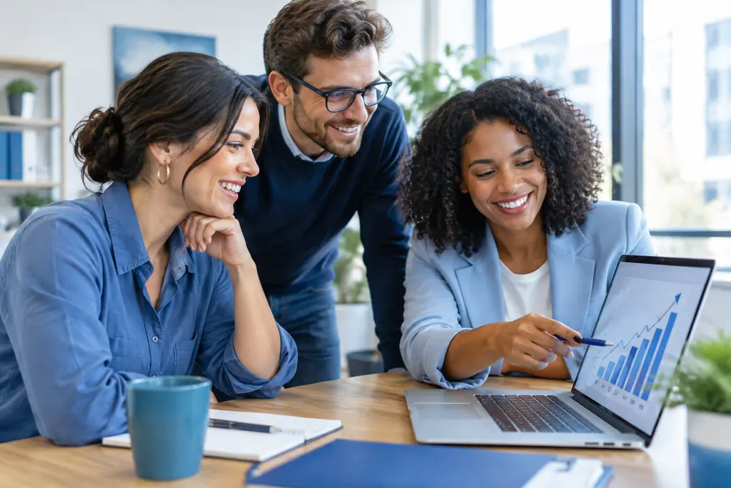 Small business team reviewing a growth chart on a laptop in a bright office